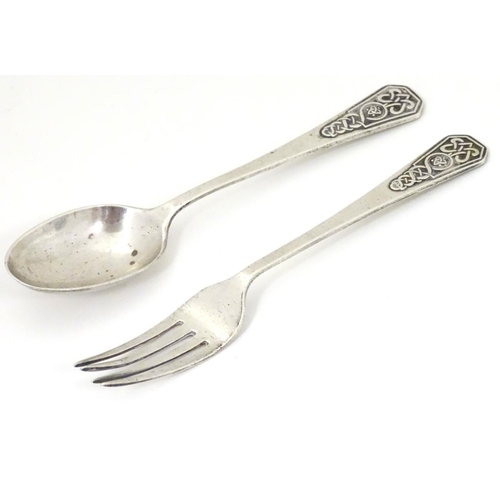 211 - A silver christening spoon and fork with Celtic decoration to handles. Hallmarked Sheffield 1948 / 1... 