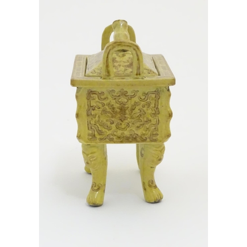 22 - A Chinese rectangular censer with a yellow ground, raised on 4 paw footed legs, with twin upright ha... 