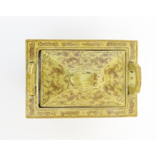 22 - A Chinese rectangular censer with a yellow ground, raised on 4 paw footed legs, with twin upright ha... 