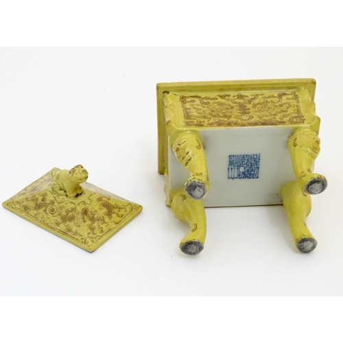 22 - A Chinese rectangular censer with a yellow ground, raised on 4 paw footed legs, with twin upright ha... 