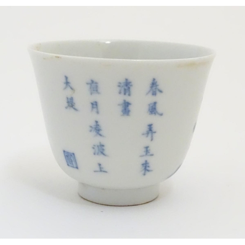 23 - A small Chinese blue and white cup decorated with flowers and Chinese script. Character marks under.... 