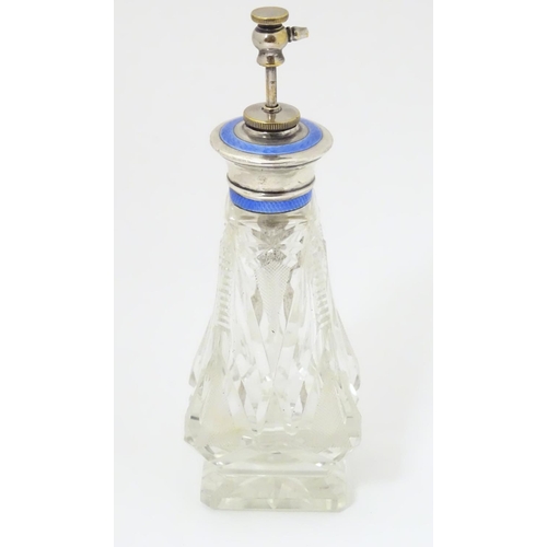 238 - A cut glass perfume / scent bottle with white metal a top having guilloche enamel decoration and ato... 