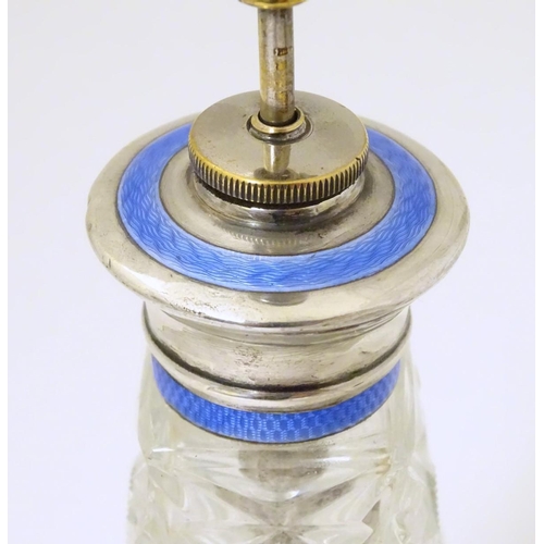 238 - A cut glass perfume / scent bottle with white metal a top having guilloche enamel decoration and ato... 