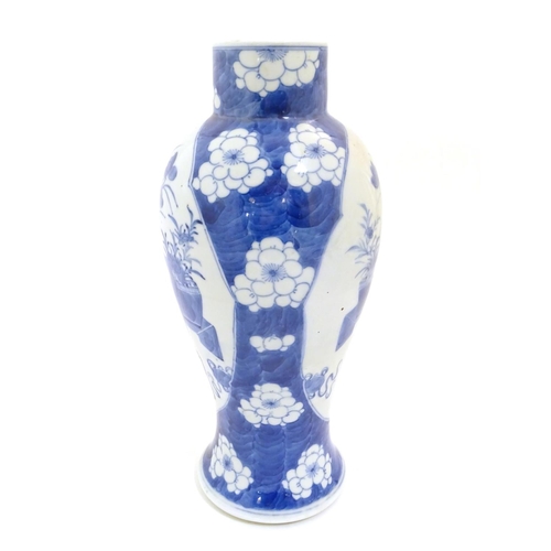 25 - A Chinese blue and white baluster vase decorated with prunus flowers, the central decoration display... 