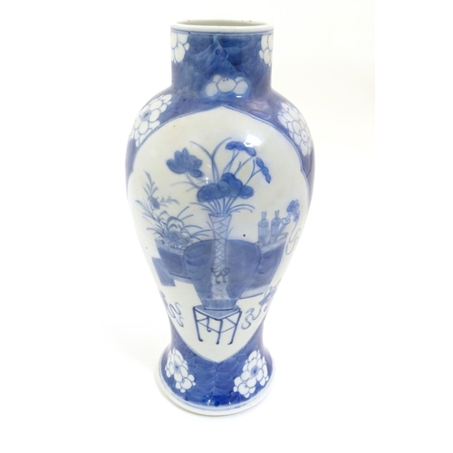 25 - A Chinese blue and white baluster vase decorated with prunus flowers, the central decoration display... 