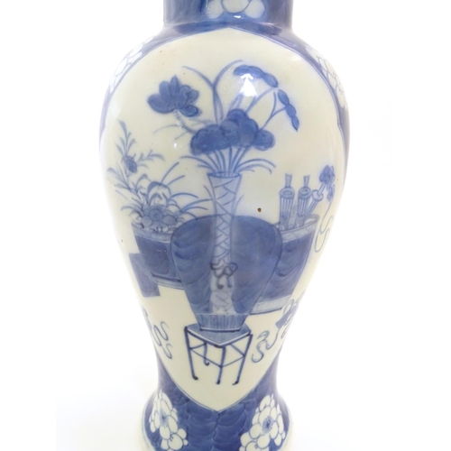 25 - A Chinese blue and white baluster vase decorated with prunus flowers, the central decoration display... 