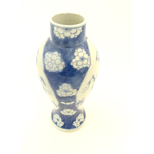 25 - A Chinese blue and white baluster vase decorated with prunus flowers, the central decoration display... 