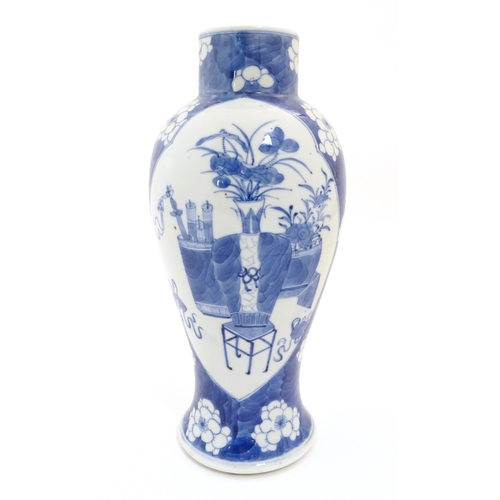 25 - A Chinese blue and white baluster vase decorated with prunus flowers, the central decoration display... 