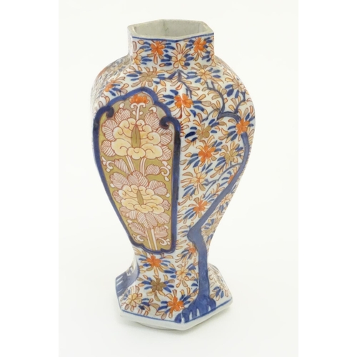 27 - An Imari style hexagonal vase with panelled floral decoration and gilt highlights. 7 1/2'' high.