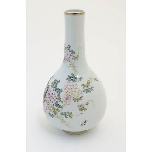 28 - A Chinese globular vase with an elongated neck decorated with peacocks and flowers in a landscape, w... 