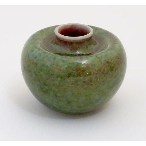 29 - A small Chinese brush washer of circular form in a mottled green and pink glaze. Character marks und... 