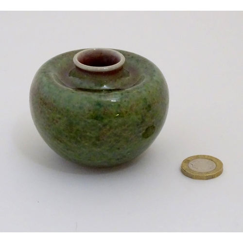 29 - A small Chinese brush washer of circular form in a mottled green and pink glaze. Character marks und... 