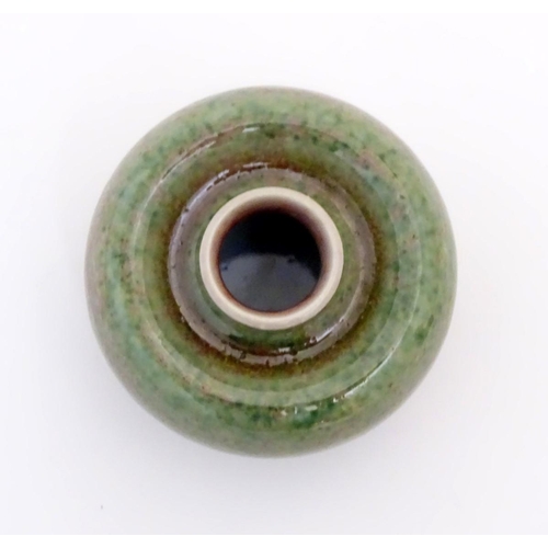 29 - A small Chinese brush washer of circular form in a mottled green and pink glaze. Character marks und... 