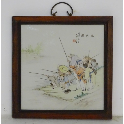 36 - A 20thC Chinese wooden wall hanging with a porcelain panel depicting elders fishing on the bank of a... 