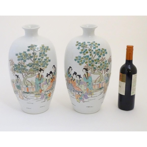 43 - A pair of 20thC Chinese vases decorated with figures on a terrace in a landscape. Approx. 15'' high ... 