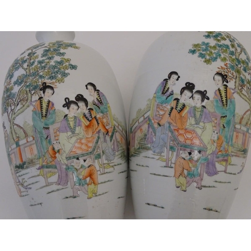 43 - A pair of 20thC Chinese vases decorated with figures on a terrace in a landscape. Approx. 15'' high ... 