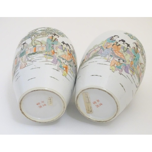 43 - A pair of 20thC Chinese vases decorated with figures on a terrace in a landscape. Approx. 15'' high ... 