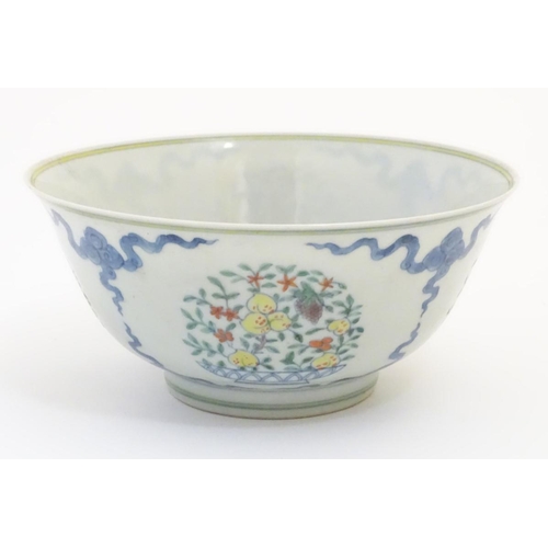 44 - A Chinese doucai bowl decorated with vases fruiting trees. Character marks under. Approx. 3 1/2'' hi... 