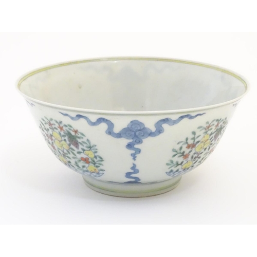 44 - A Chinese doucai bowl decorated with vases fruiting trees. Character marks under. Approx. 3 1/2'' hi... 