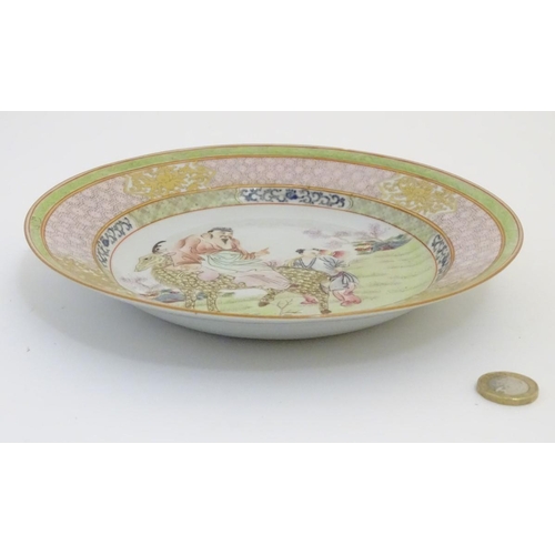 51 - A Chinese famille rose plate decorated with Shou-Lao, the God of Longevity, riding a spotted deer in... 