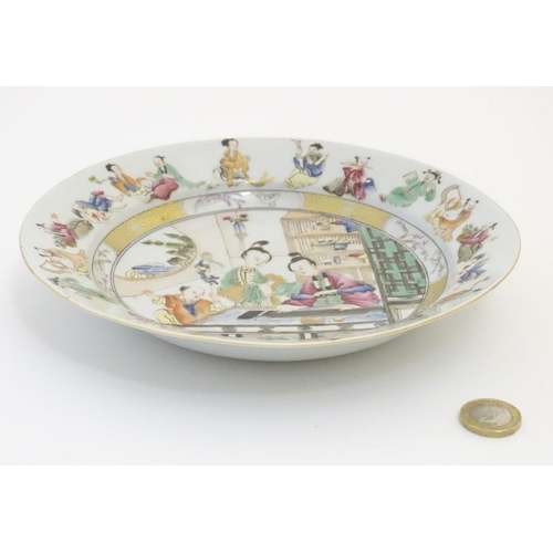 56 - A Chinese plate decorated with figures in an interior playing a guqin. The border decorated with fig... 