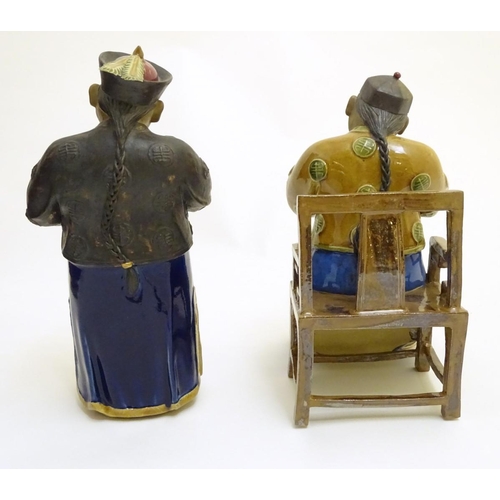 57 - Two ceramic figures of Chinese men in traditional dress drinking tea, one seated, the other standing... 