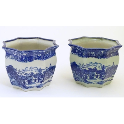 64 - A pair of Masons style blue and white octagonal jardinieres depicting an urban scene with buildings,... 