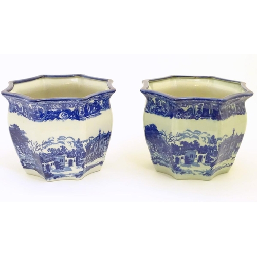 64 - A pair of Masons style blue and white octagonal jardinieres depicting an urban scene with buildings,... 