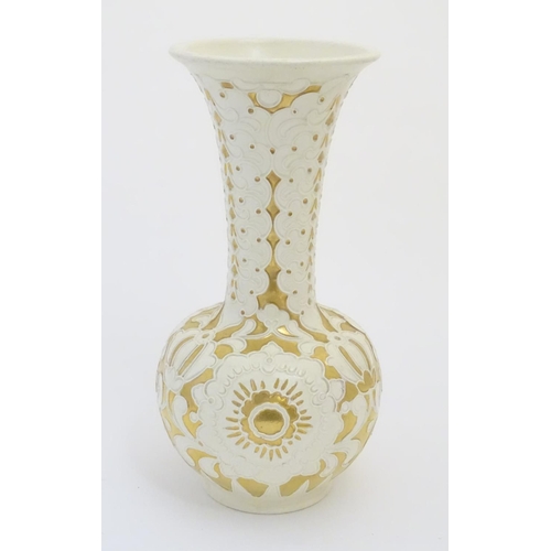 83 - A large cream Burmantofts Faience vase with an elongated neck and a flared rim, decorated with styli... 