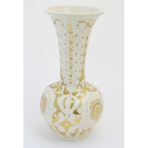 83 - A large cream Burmantofts Faience vase with an elongated neck and a flared rim, decorated with styli... 