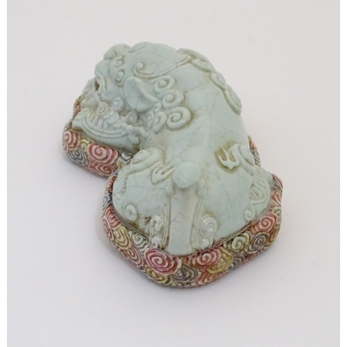 9 - A recumbent Chinese foo dog with a crackle glaze lying on a bed of stylised clouds. Character marks ... 