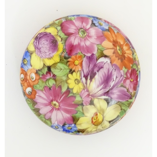 91 - A hand painted German powder bowl / lidded pot, decorated with colourful flowers, with a gilt rim an... 