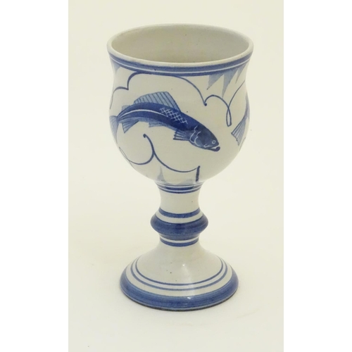 93 - A Laurence McGowan British studio pottery goblet with blue hand painted fish decoration. Monogram an... 