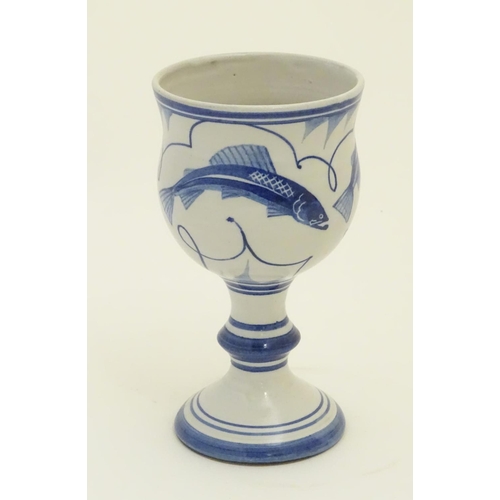 93 - A Laurence McGowan British studio pottery goblet with blue hand painted fish decoration. Monogram an... 