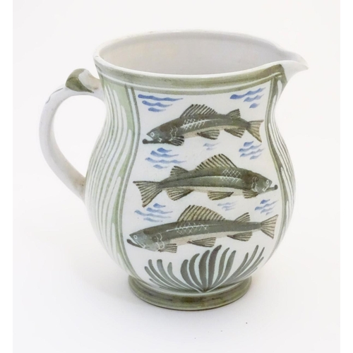 95 - A Laurence McGowan British studio pottery jug, with green hand painted fish decoration. Monogram to ... 