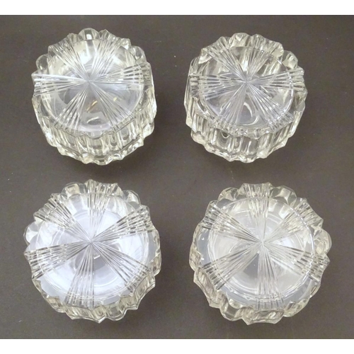 119 - A set of four 19thC glass scent bottles and stoppers with cut decoration within a wooden box. Each s... 