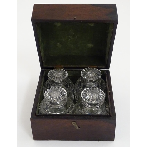 119 - A set of four 19thC glass scent bottles and stoppers with cut decoration within a wooden box. Each s... 