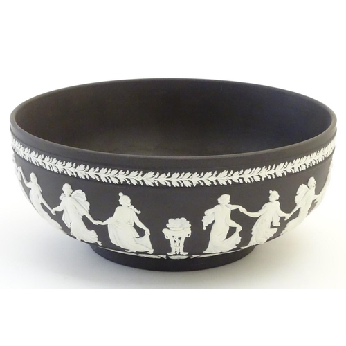 85 - A black Wedgwood Jasperware bowl decorated with classical figures, the Dancing Hours, with a border ... 
