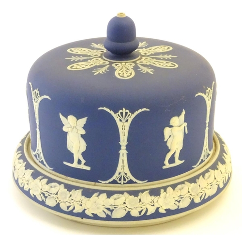 86 - A blue and white cheese dome and stand in the manner of Wedgwood Jasperware, decorated with putti / ... 
