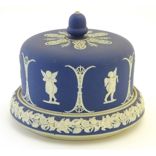 86 - A blue and white cheese dome and stand in the manner of Wedgwood Jasperware, decorated with putti / ... 