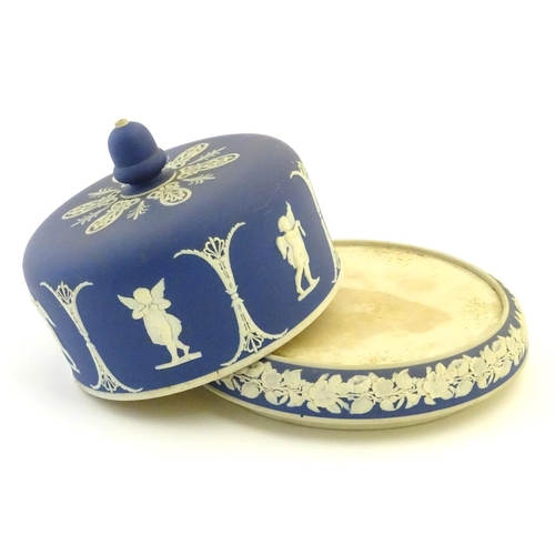 86 - A blue and white cheese dome and stand in the manner of Wedgwood Jasperware, decorated with putti / ... 