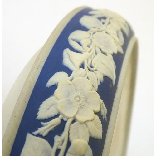 86 - A blue and white cheese dome and stand in the manner of Wedgwood Jasperware, decorated with putti / ... 