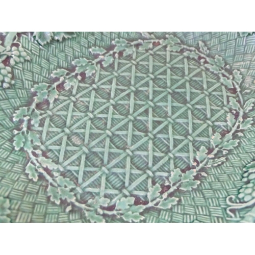 94 - A pair of Wedgwood majolica oval plates with a green lustre glaze, decorated with moulded grape vine... 