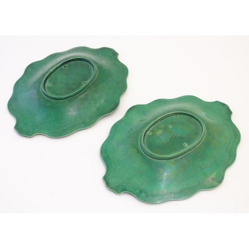 94 - A pair of Wedgwood majolica oval plates with a green lustre glaze, decorated with moulded grape vine... 