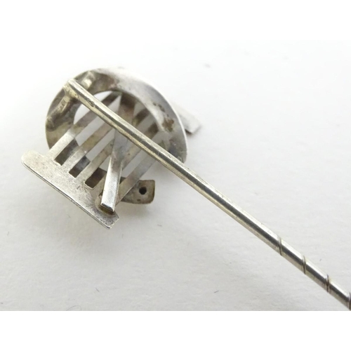 209 - A white metal stick pin surmounted by a horseshoe and gate. Approx 3'' long
