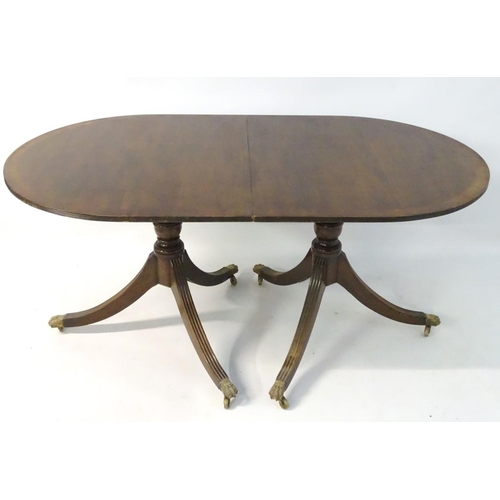 183 - An early 20thC mahogany Regency style dining table, with splayed fluted sabre legs terminating in br... 
