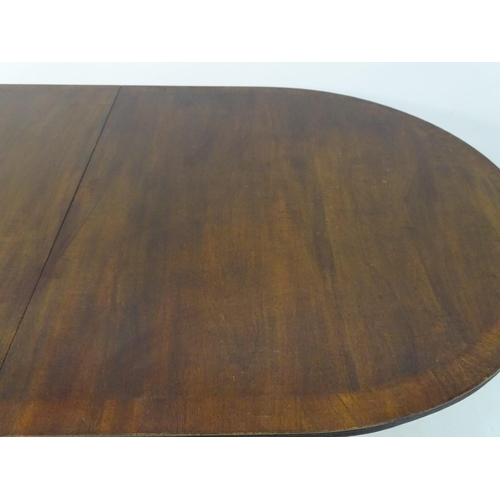 183 - An early 20thC mahogany Regency style dining table, with splayed fluted sabre legs terminating in br... 