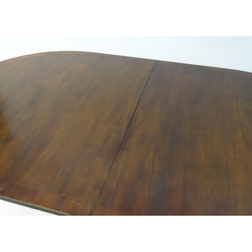 183 - An early 20thC mahogany Regency style dining table, with splayed fluted sabre legs terminating in br... 