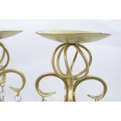 203 - A pair of tall gilt candle sticks with glass drops