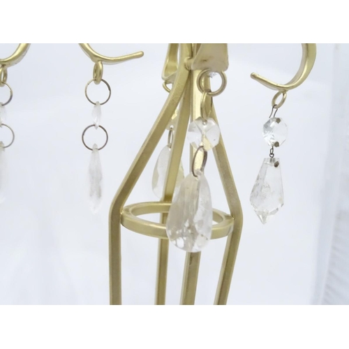 203 - A pair of tall gilt candle sticks with glass drops